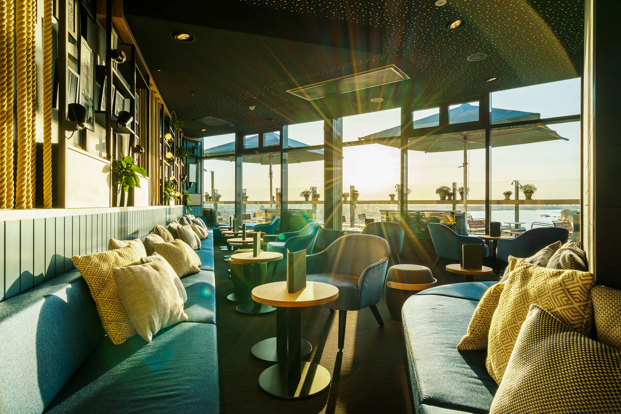 Sonne scheint durch die Bar auf dem Dach bei Sonnenuntergang