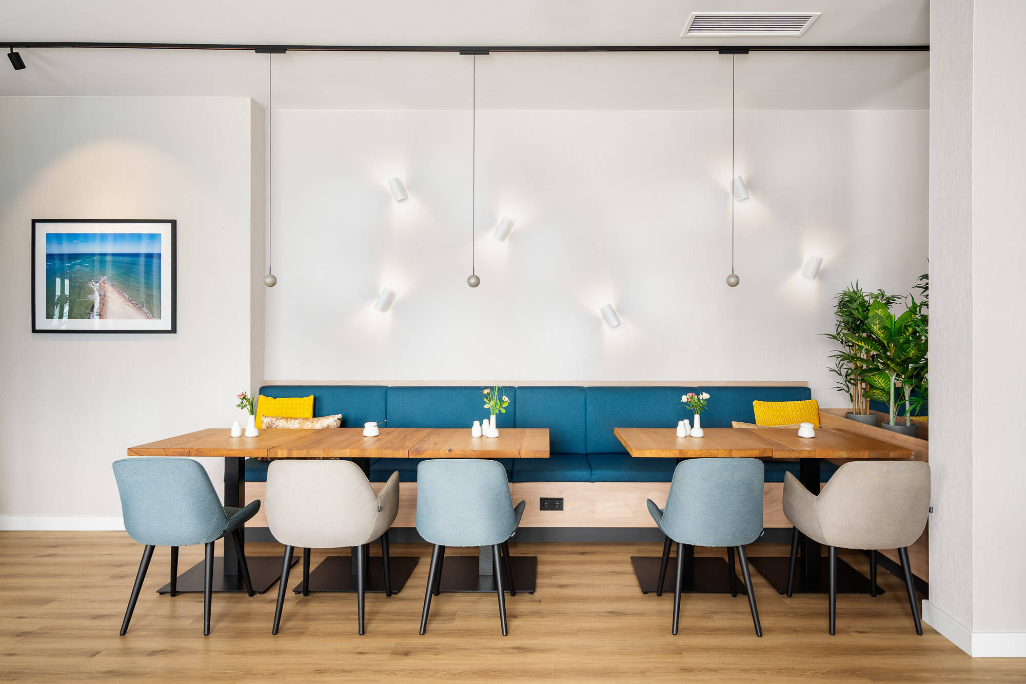 Gastraum mit blauer Polsterbank und Holztischen