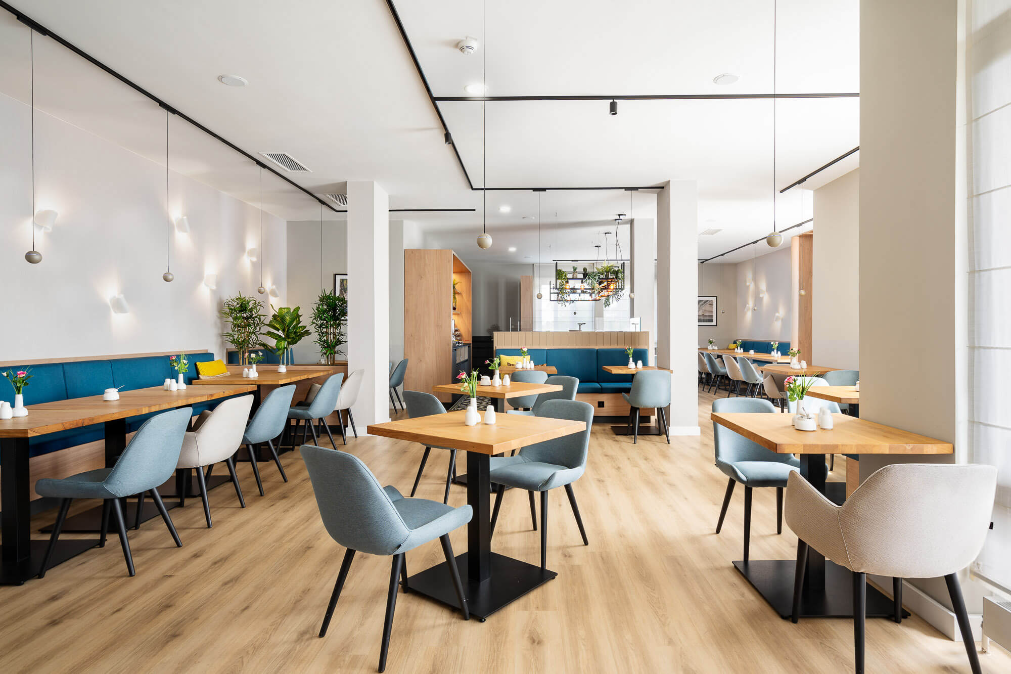 Restaurant mit Holzboden und hellen Sitzbereichen