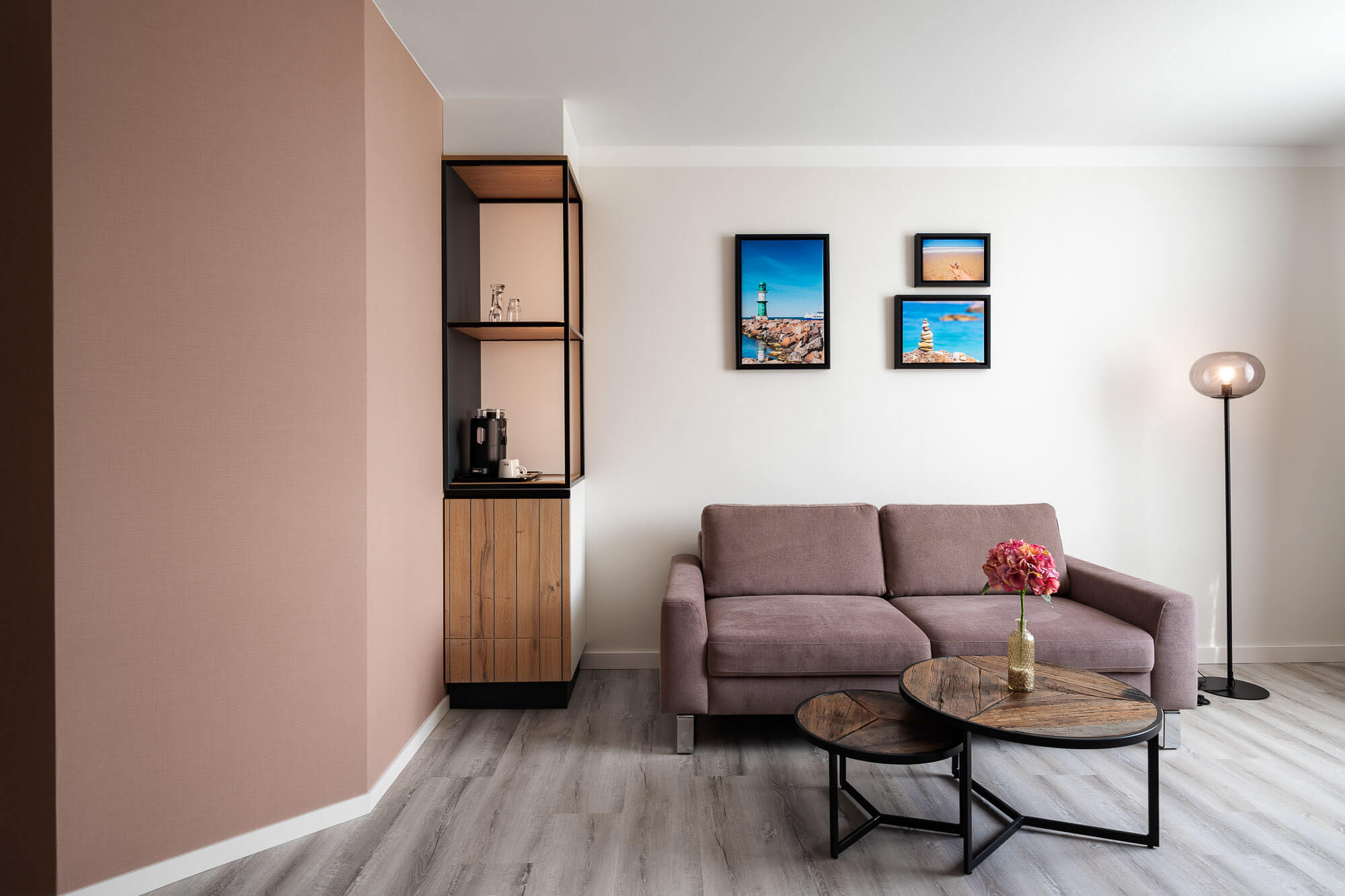 Hotel-Suite mit Sofa und Stehlampe im Wohnbereich