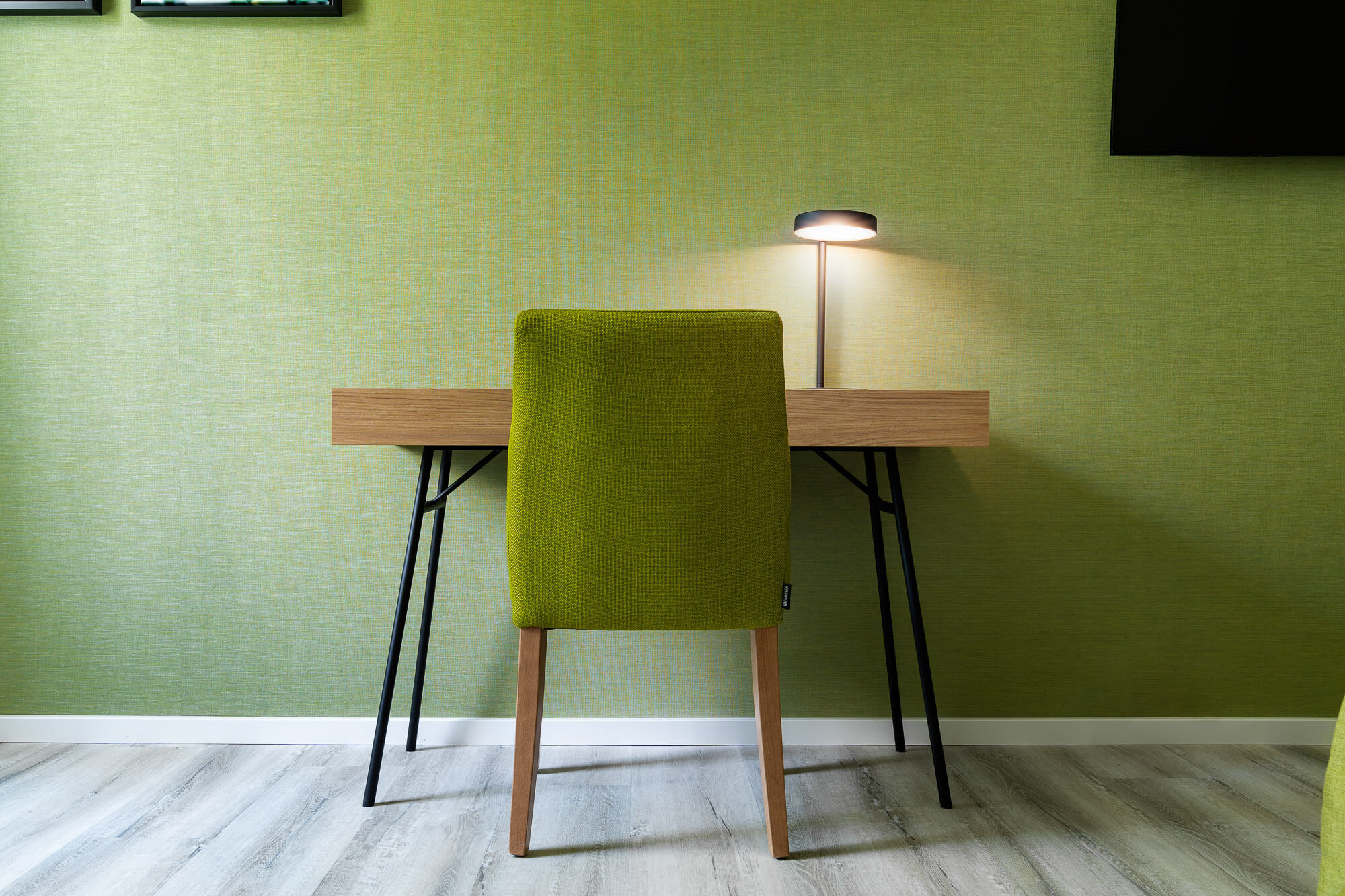 Arbeitsbereich mit grünem Stuhl und hellem Holz