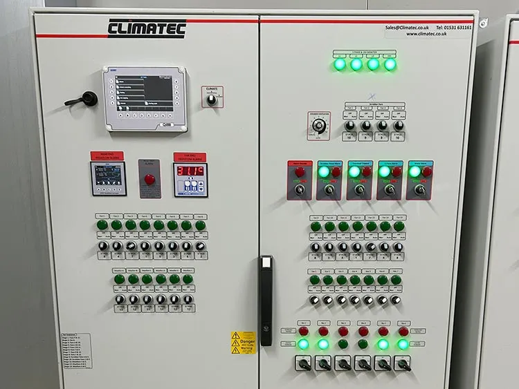 Control panel with multiple green indicator lights, knobs, switches, and digital displays labeled Climatic.