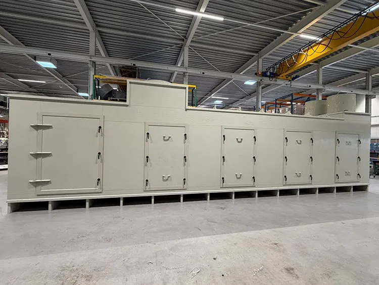 Large industrial heat exchanger with multiple access doors in a factory setting.