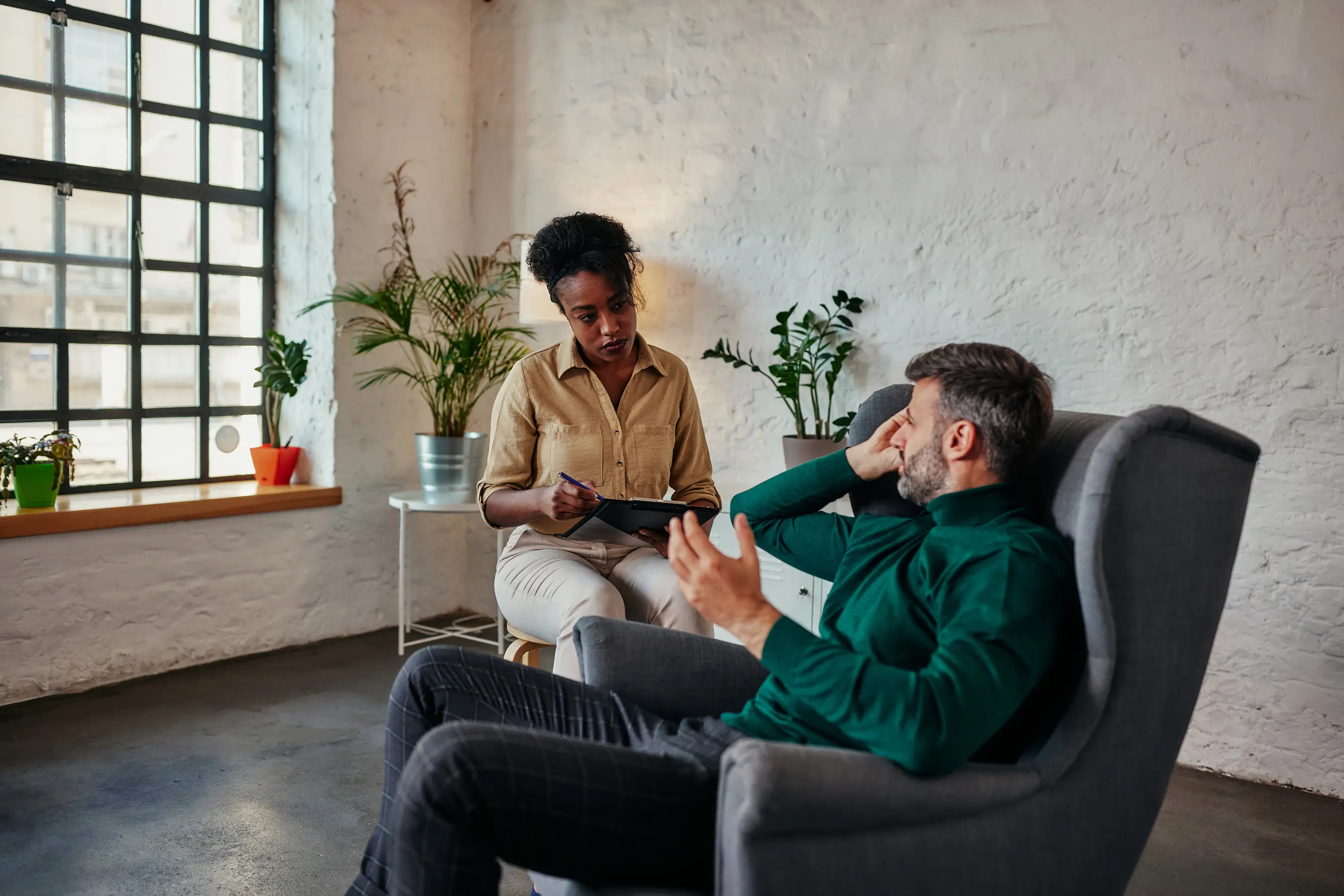 Male patient and female therapist talking during a session