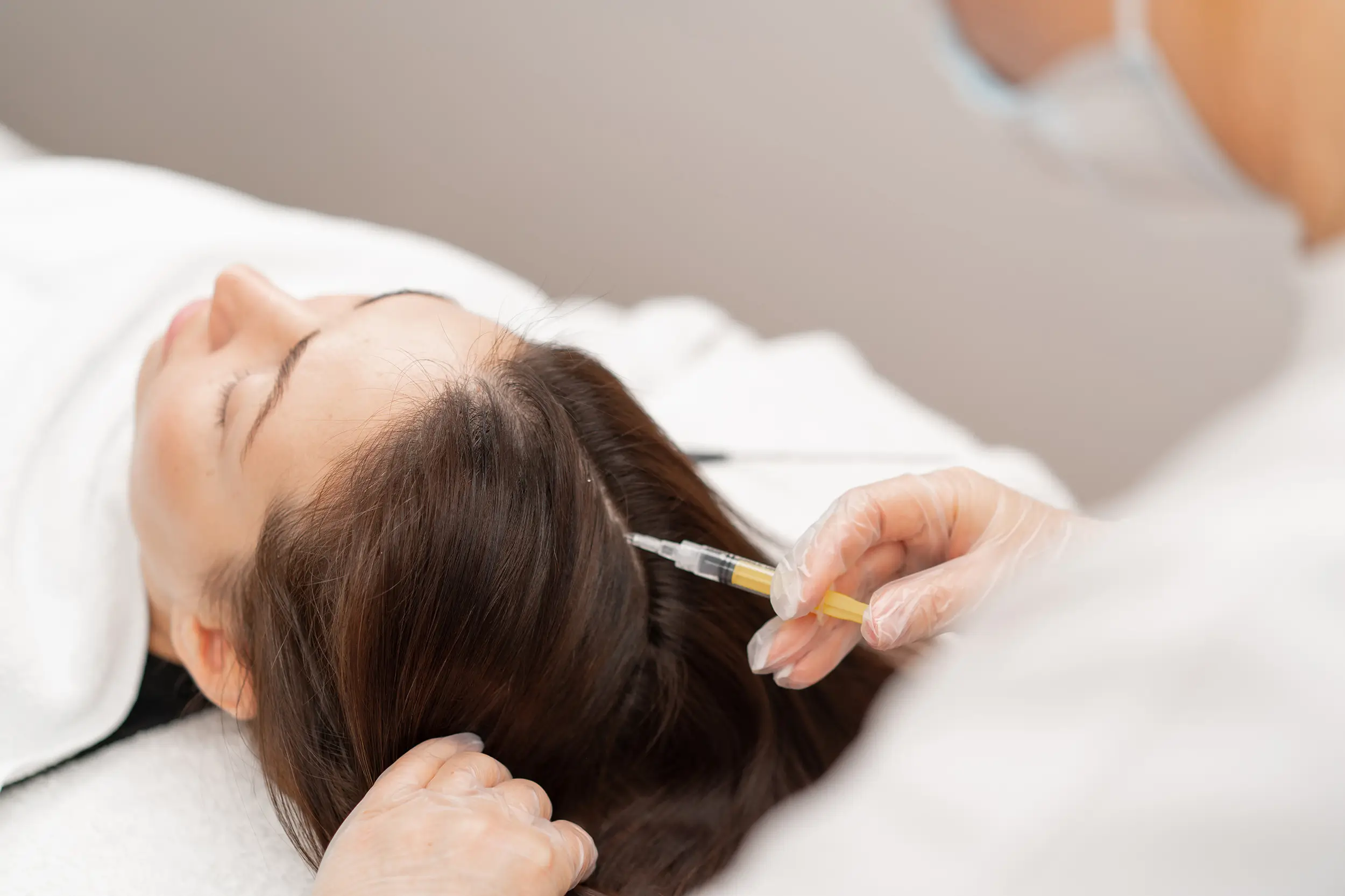 Beautician performing injection for hair rejuvenation procedure