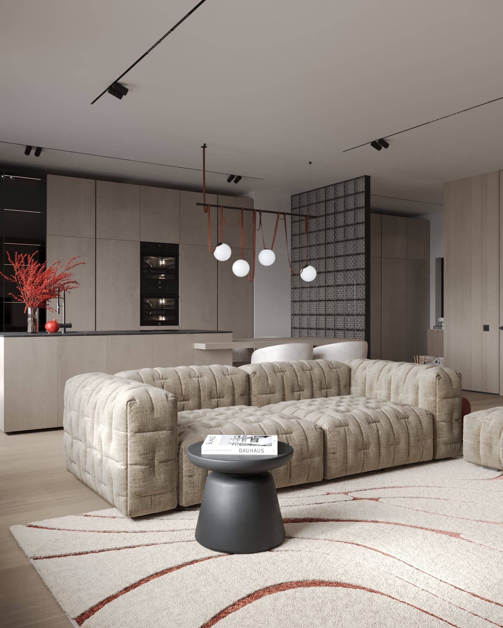 Cozy tufted beige sofa in an open-plan living room with minimalist kitchen and red accent decor