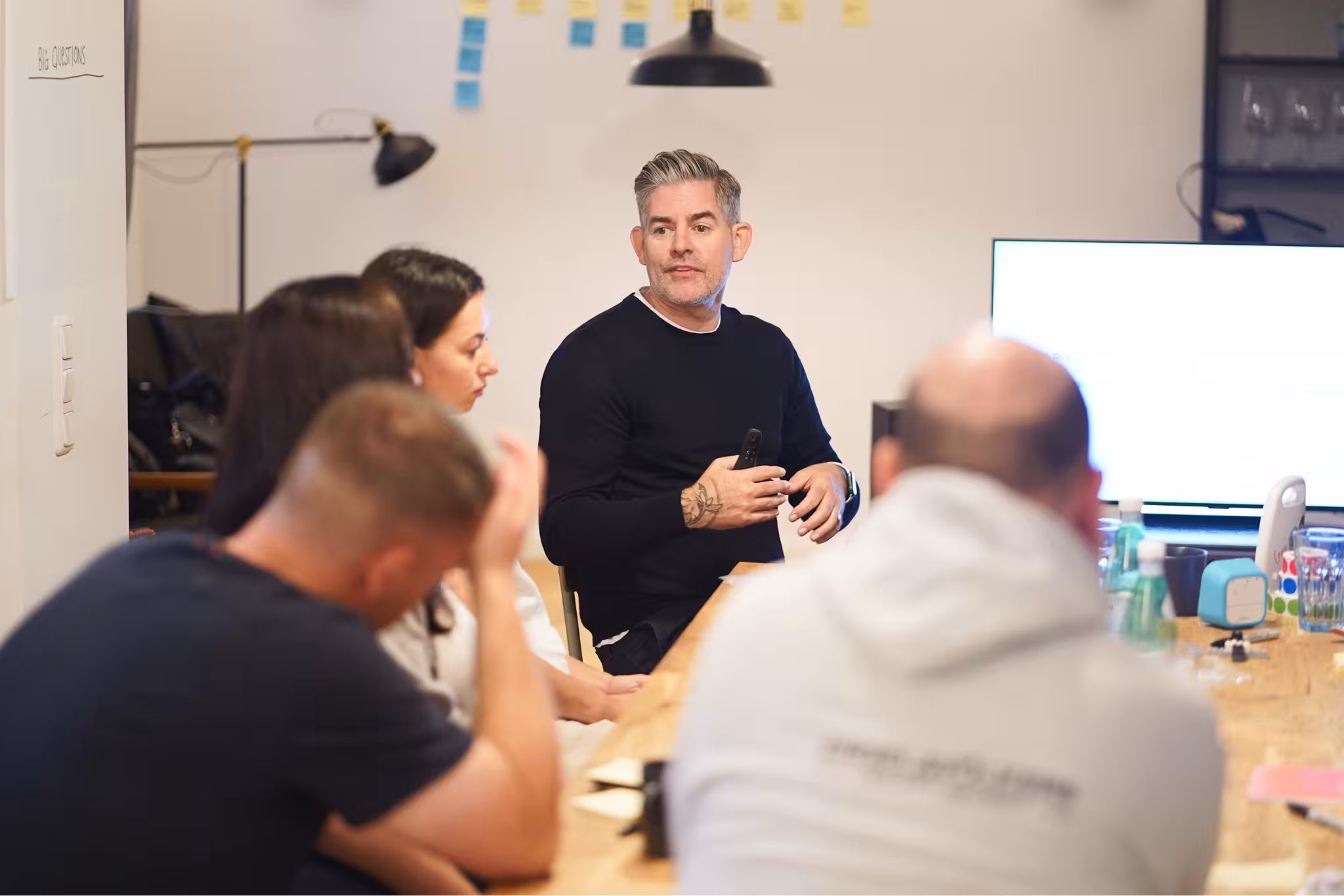 Rob Hamblen of Be The Leap speaks to startup executives during a design sprint workshop at a wooden table.