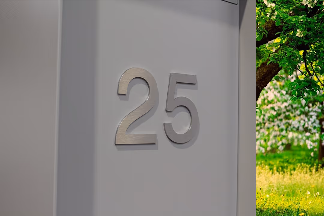 Une boîte aux lettres grise avec un gros plan sur le numéro 25.