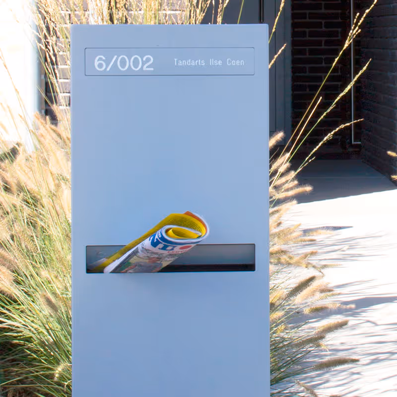 Une boîte aux lettres design gris clair pour une maison.