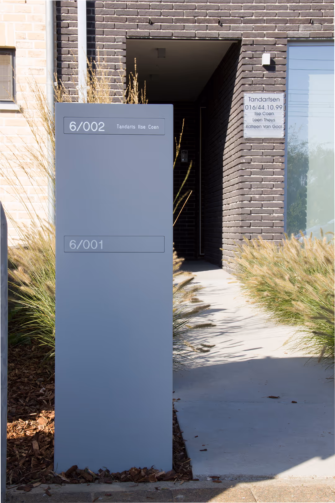 Een lichtgrijze designbrievenbus voor een huis.