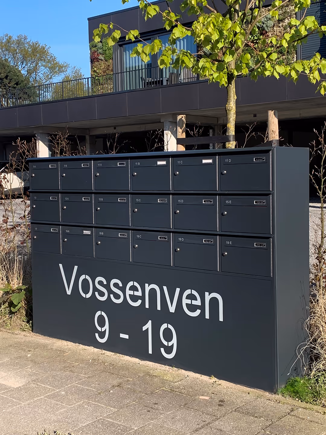 Boîte aux lettres gris foncé sur mesure avec le nom de la résidence.