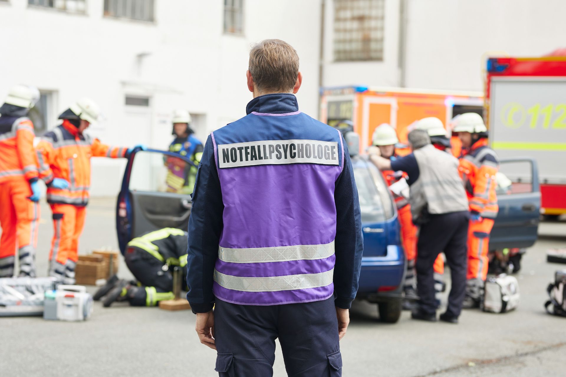 Ein Notfallpsychologe im EInsatz von hinten über die Schulter fotografiert.