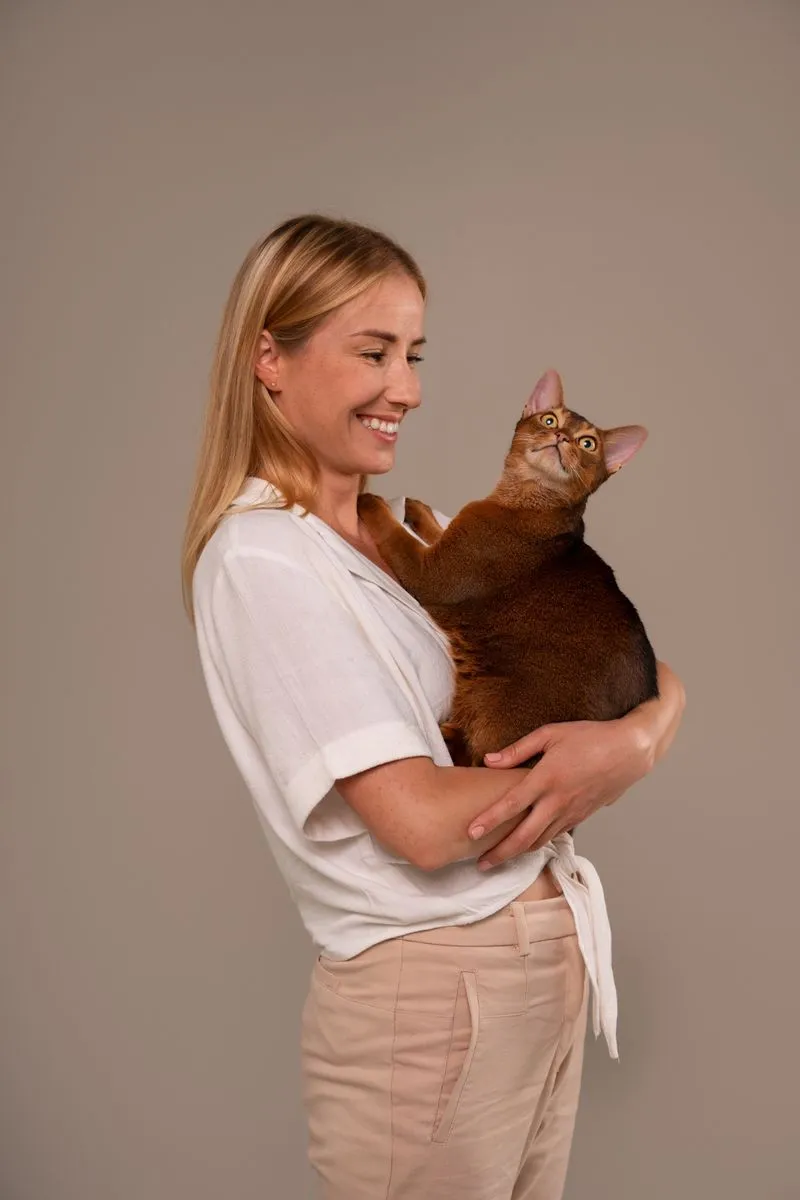 A woman holding a cat in her arms.