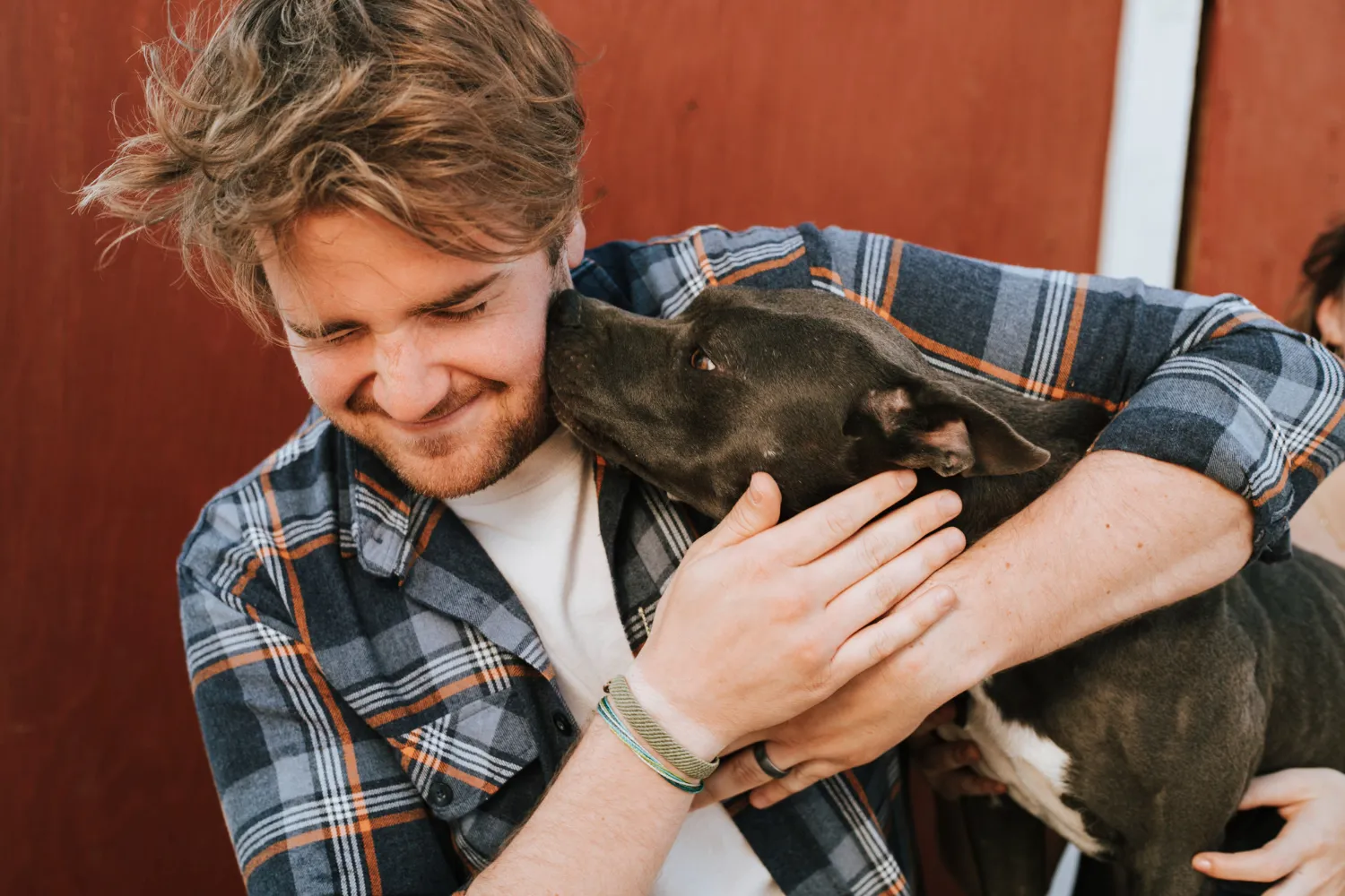 A man holding a dog in his arms.
