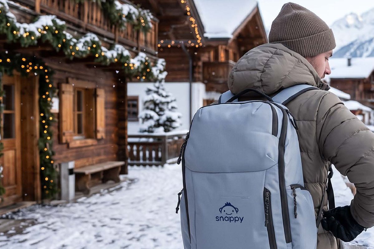 Traveler wearing a Snappy-branded backpack in a snowy village