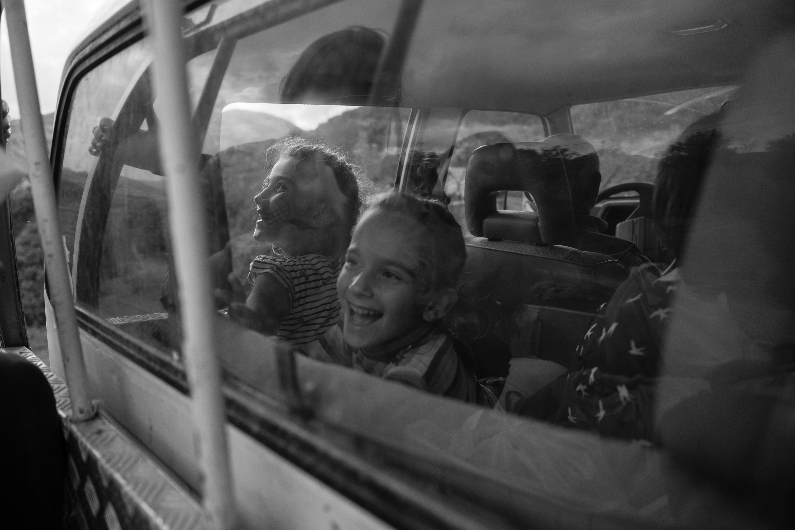 Children laughing behind the window of an old bus in the Albanian mountains