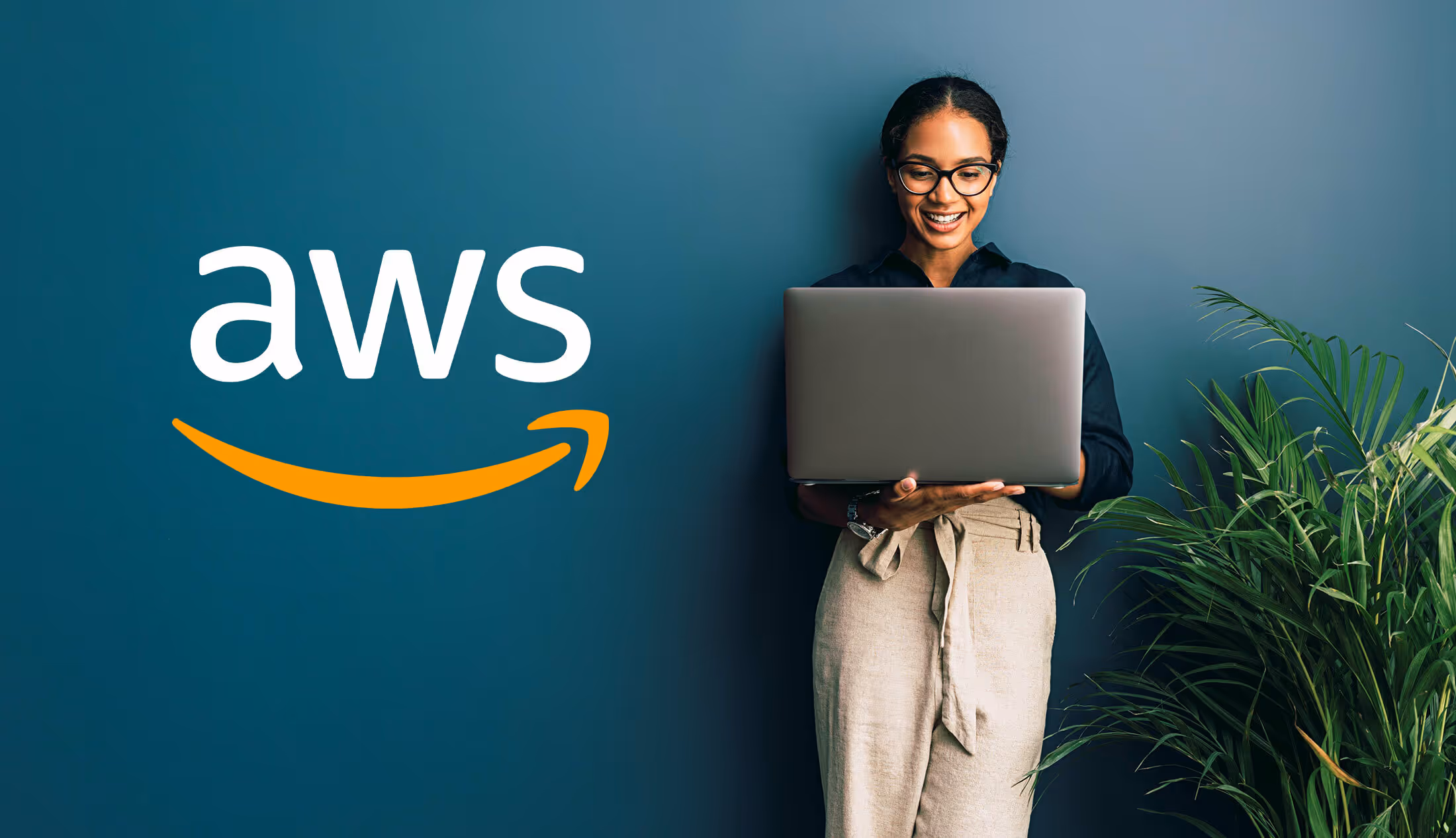 A photo of a woman working on a laptop with the AWS logo in the upper corner of the photo