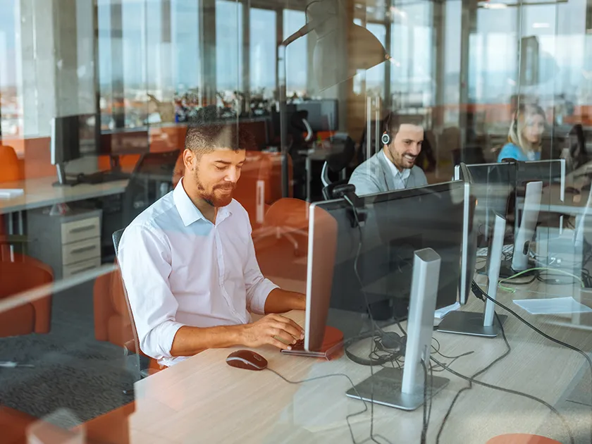 A man sitting at a desk in front of a computer.