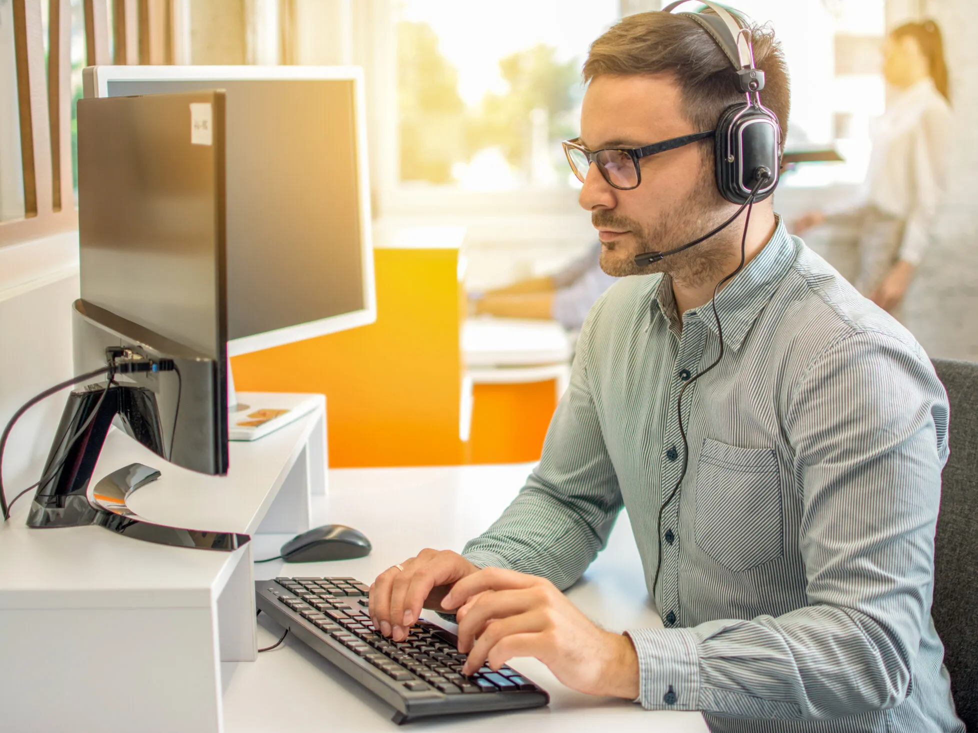 A man wearing headphones and using a computer.