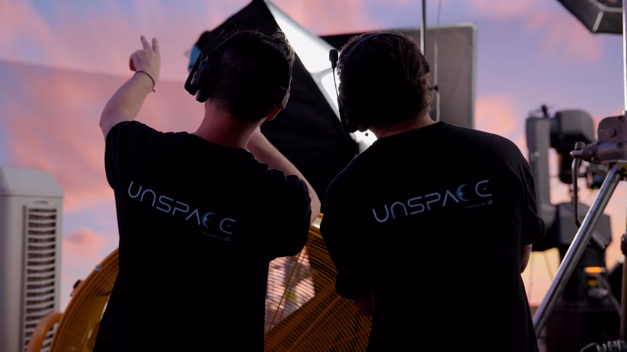 UNSPACE crew adjusting lighting on rooftop virtual-production set during sunset inside Turin LED studio.