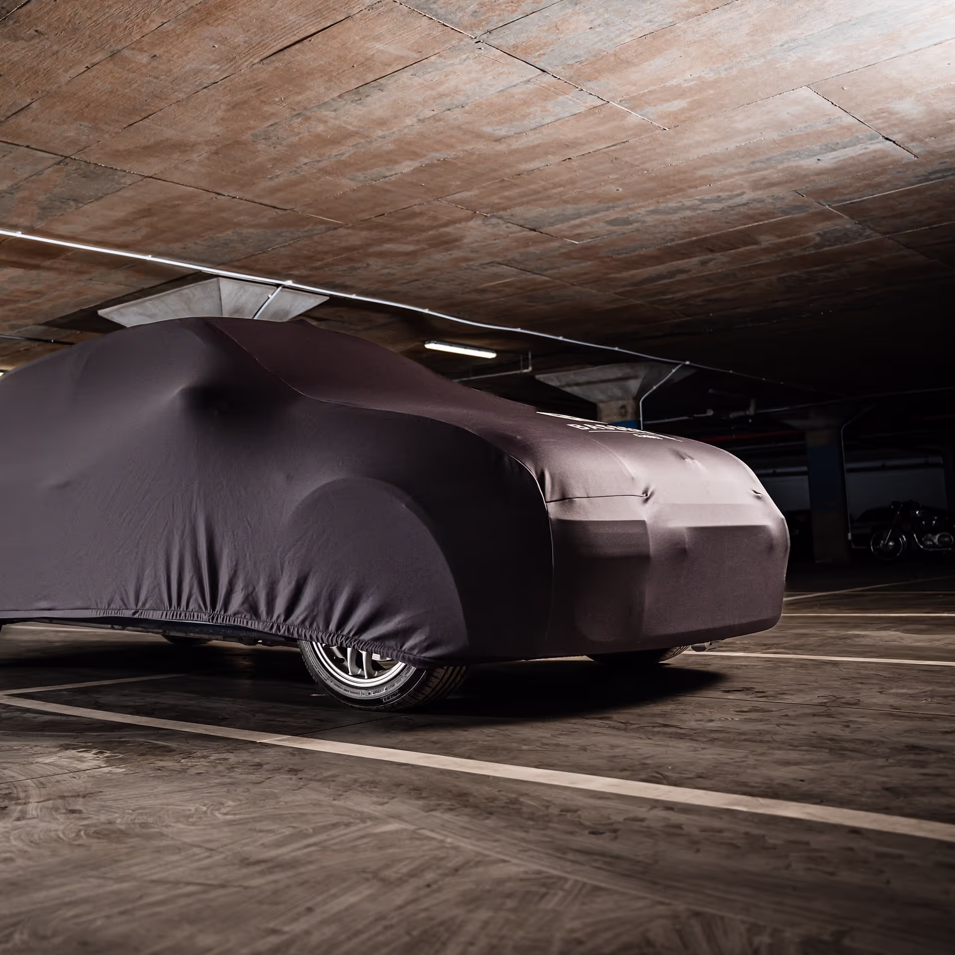 A covered car parked in secure basement storage