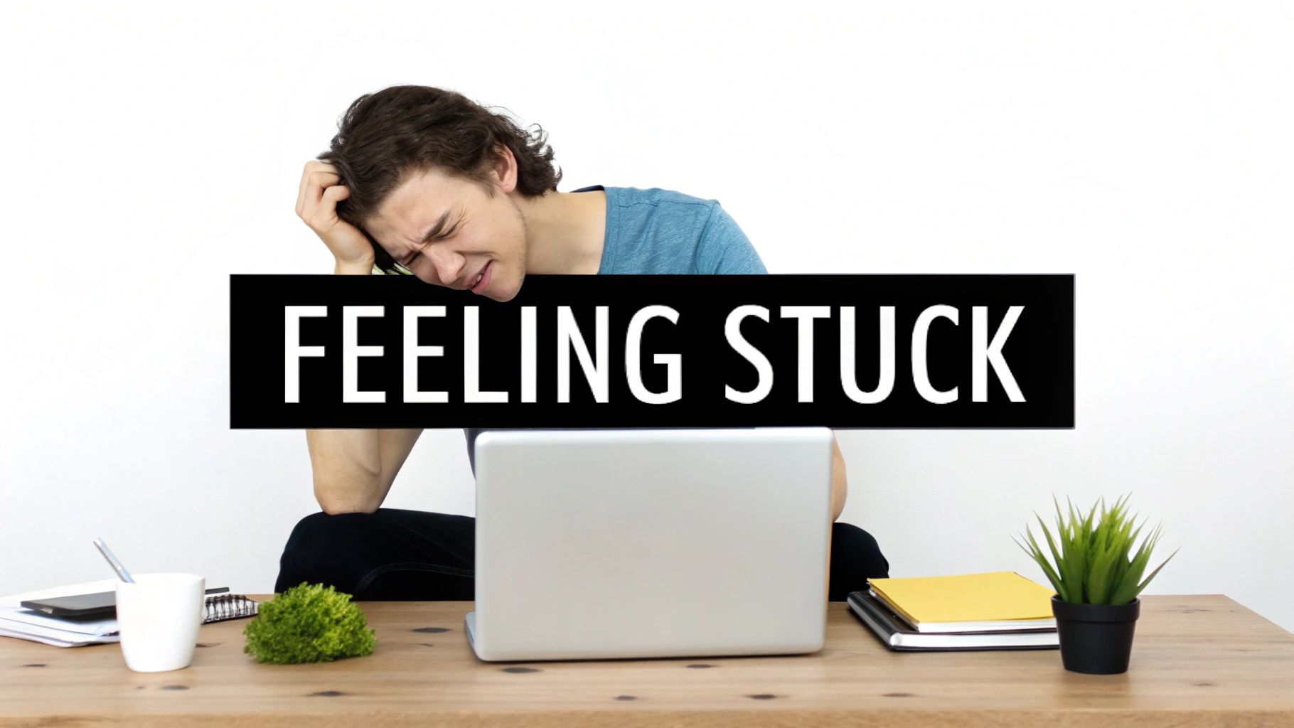 Young man looking overwhelmed and stressed at his desk with a 'FEELING STUCK' banner.