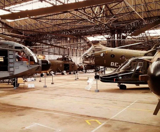 Interior view of a museum exhibiting several military helicopters v