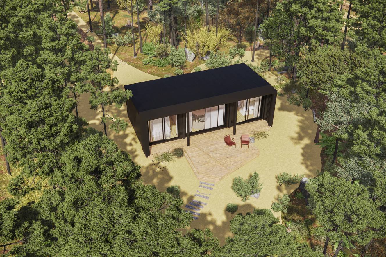 Villa moderne noire avec terrasse en bois et deux fauteuils, entourée d'une forêt dense.