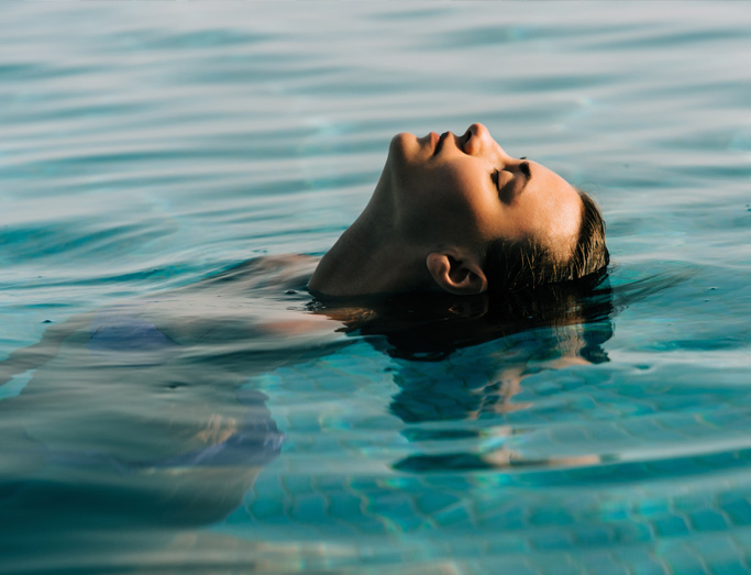 Vrouw ontspant in een zwembad voor een moment van ontspanning
