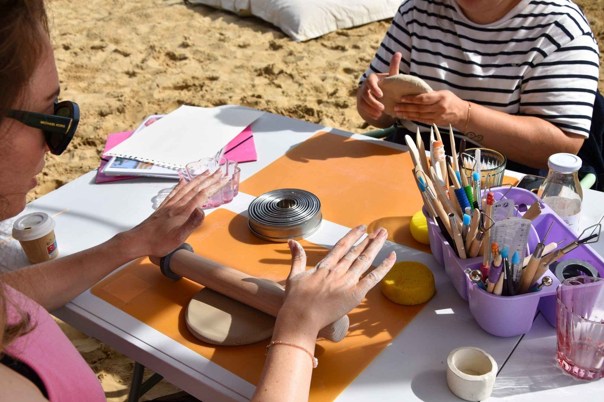 Participants modelant l'argile lors d'un atelier Solua Atelier sur le sable, chez BonjourSauvage Seignosse