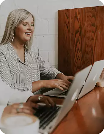 Femme souriante qui travaille sur l'ordinateur - Stratégie social media