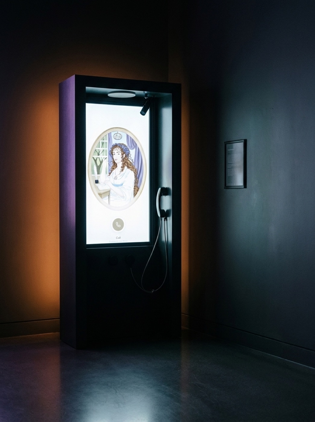 A physical Ask Mona totem in a dark room: a portrait screen showing Dorothea Herbert, with a handset and a framed sign on the wall