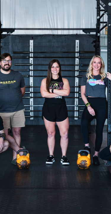 Strength & Conditioning gym interior at Norman Strength & Conditioning in Norman, OK, featuring workout equipment and athletes in action.