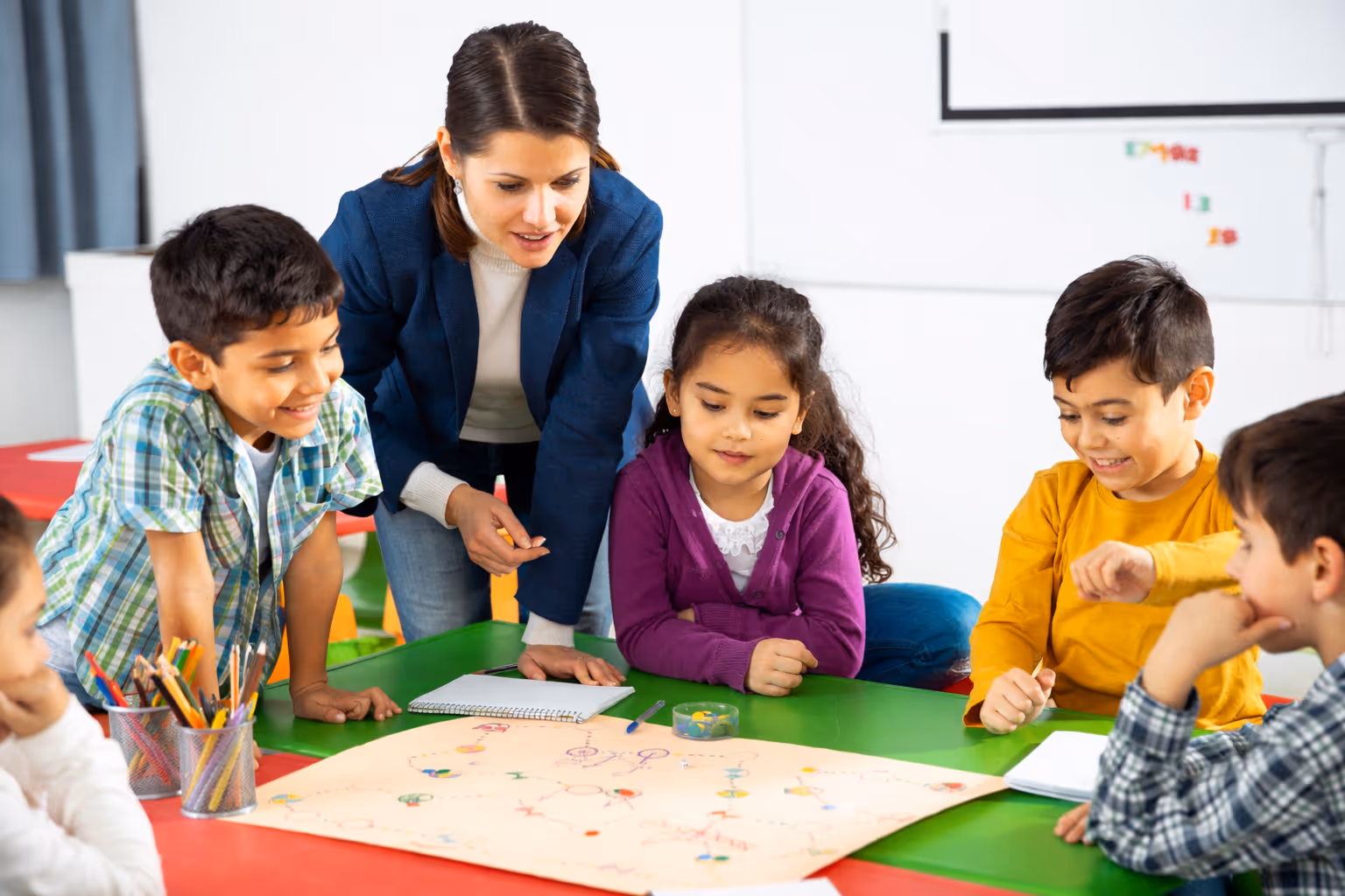 Teacher working at a table with a small group of Latino elementary-level students