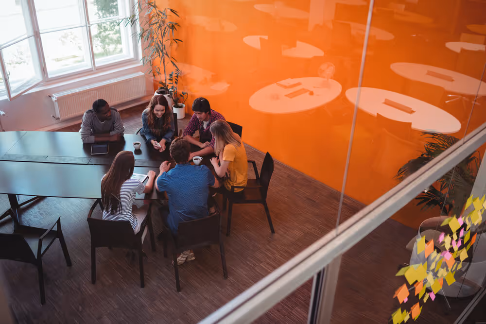 Far away picture of people gathered around a meeting table
