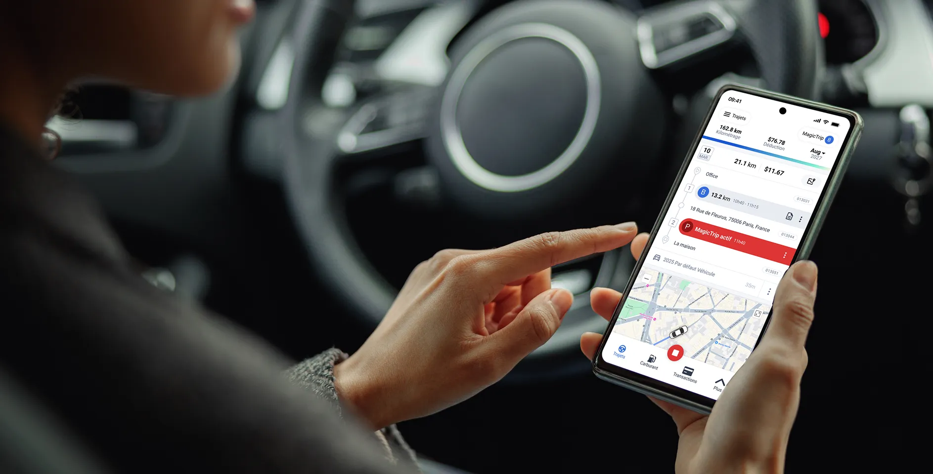 une personne assise dans sa voiture, regardant l'application mobile Triplog pendant que le trajet est en cours, montrant comment le kilométrage est suivi