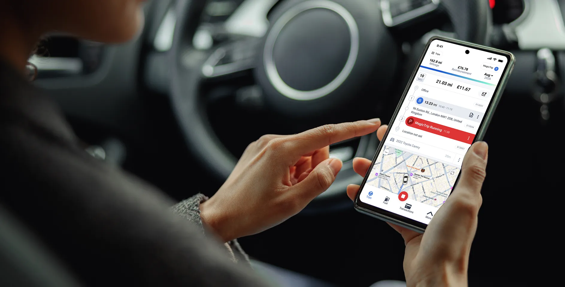 a person sitting in their car, looking at the triplog mobile app while trip is running, showing how mileage is tracked