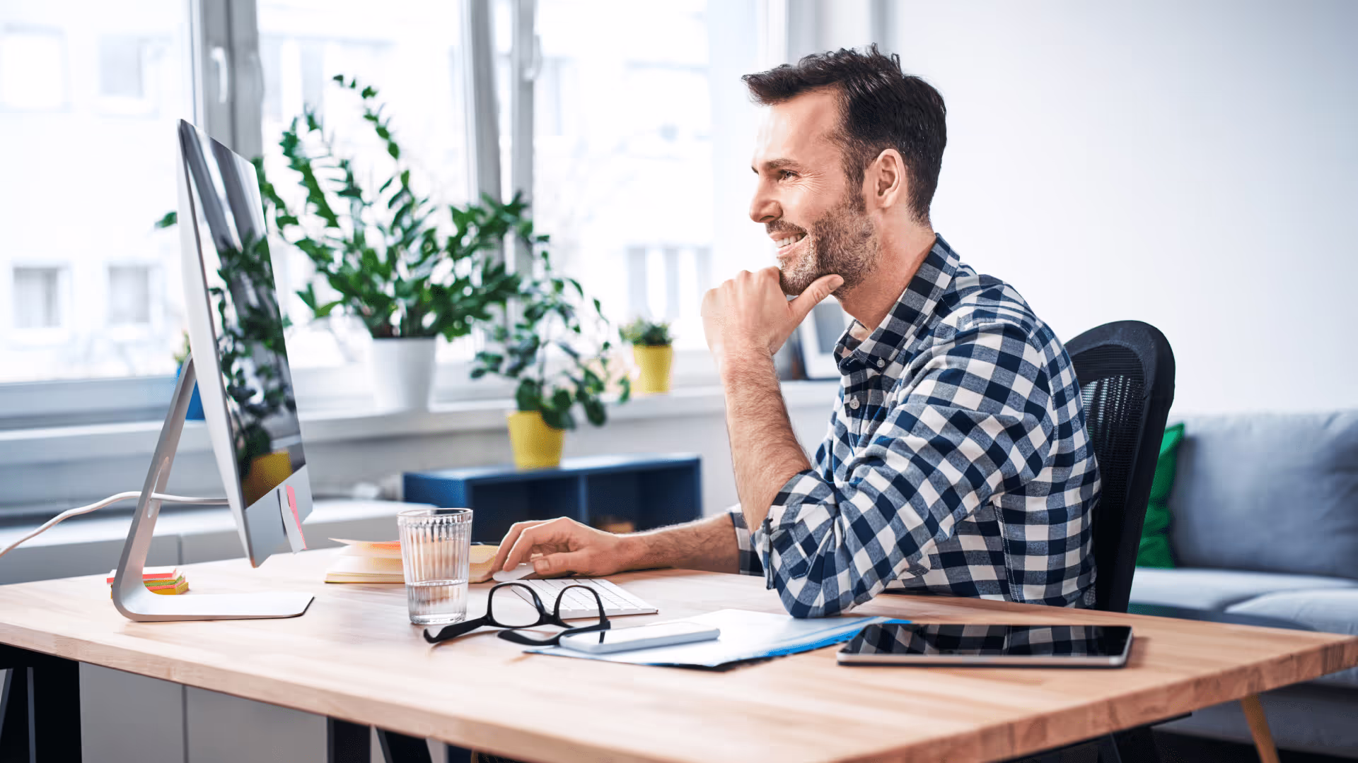 small business owner sitting at desk|small-business-owner-standing-by-desk