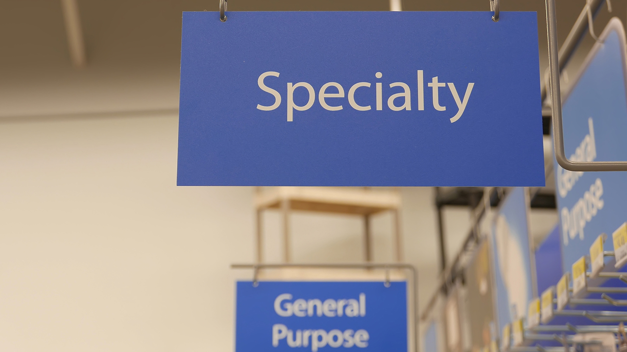Blue hanging sign reading Speciality in a Walmart store Walmart Spark Driver article cover image