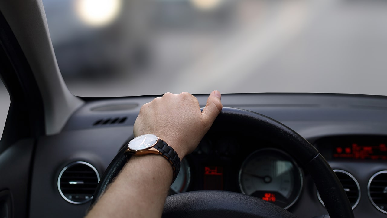 Uber driver's hand on steering wheel while driving