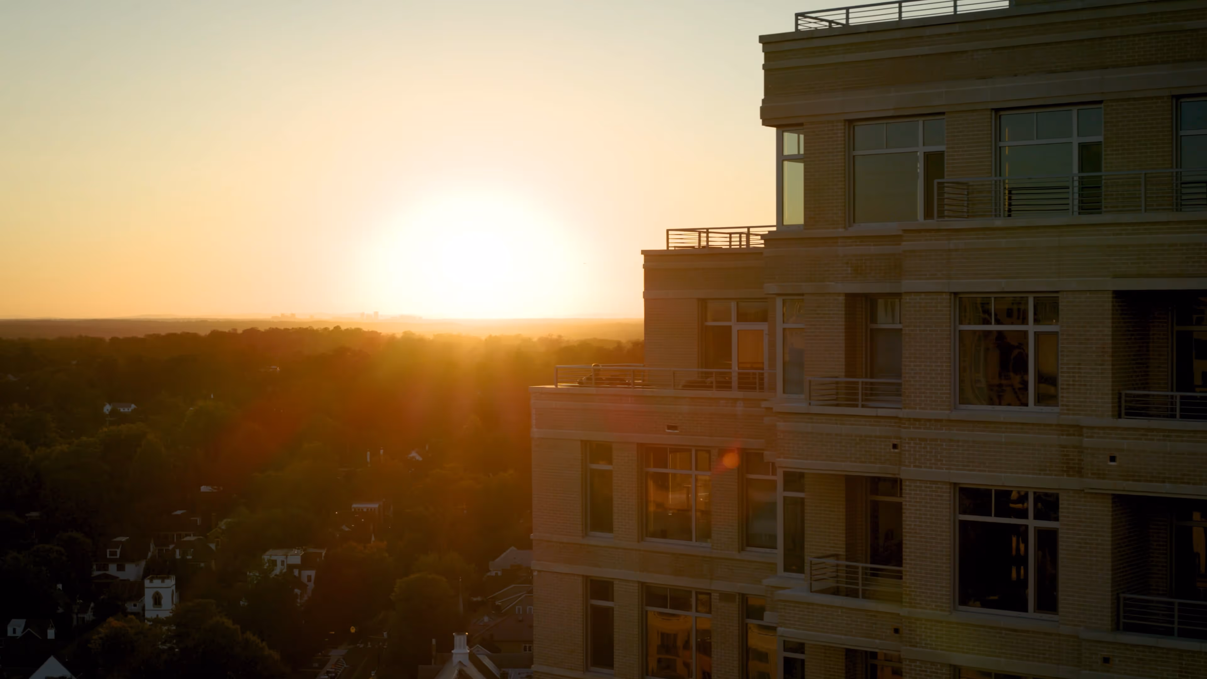 sunset on an apartment building with trees in the background