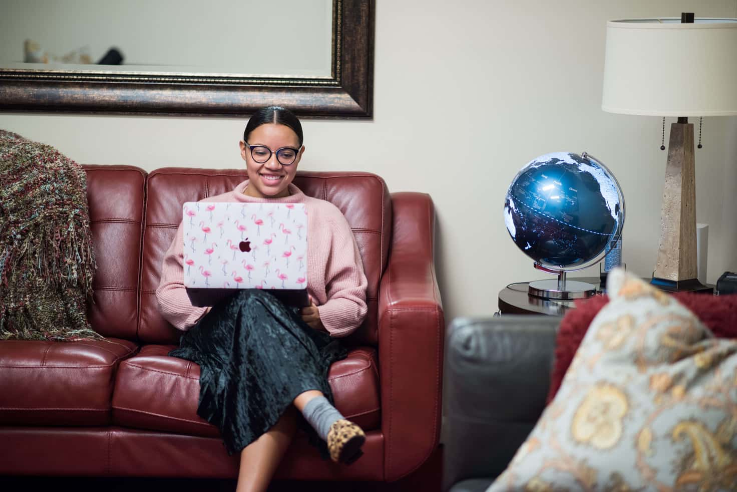 A woman sitting on a couch on her laptop