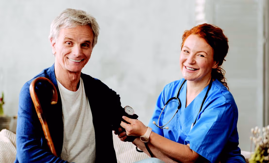 Female nurse checking older gentleman's blood pressure