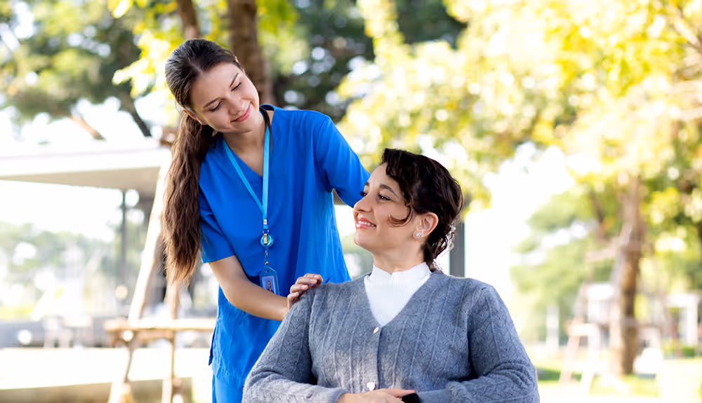Nurse standing next to young woman sitting down