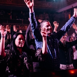 Worshipers raising their hands in surrender, calling on the Lord to move powerfully and awaken hearts