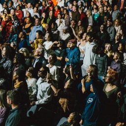 A standing crowd lifting their hands in unified worship, crying out for revival and God’s movement across the nation.