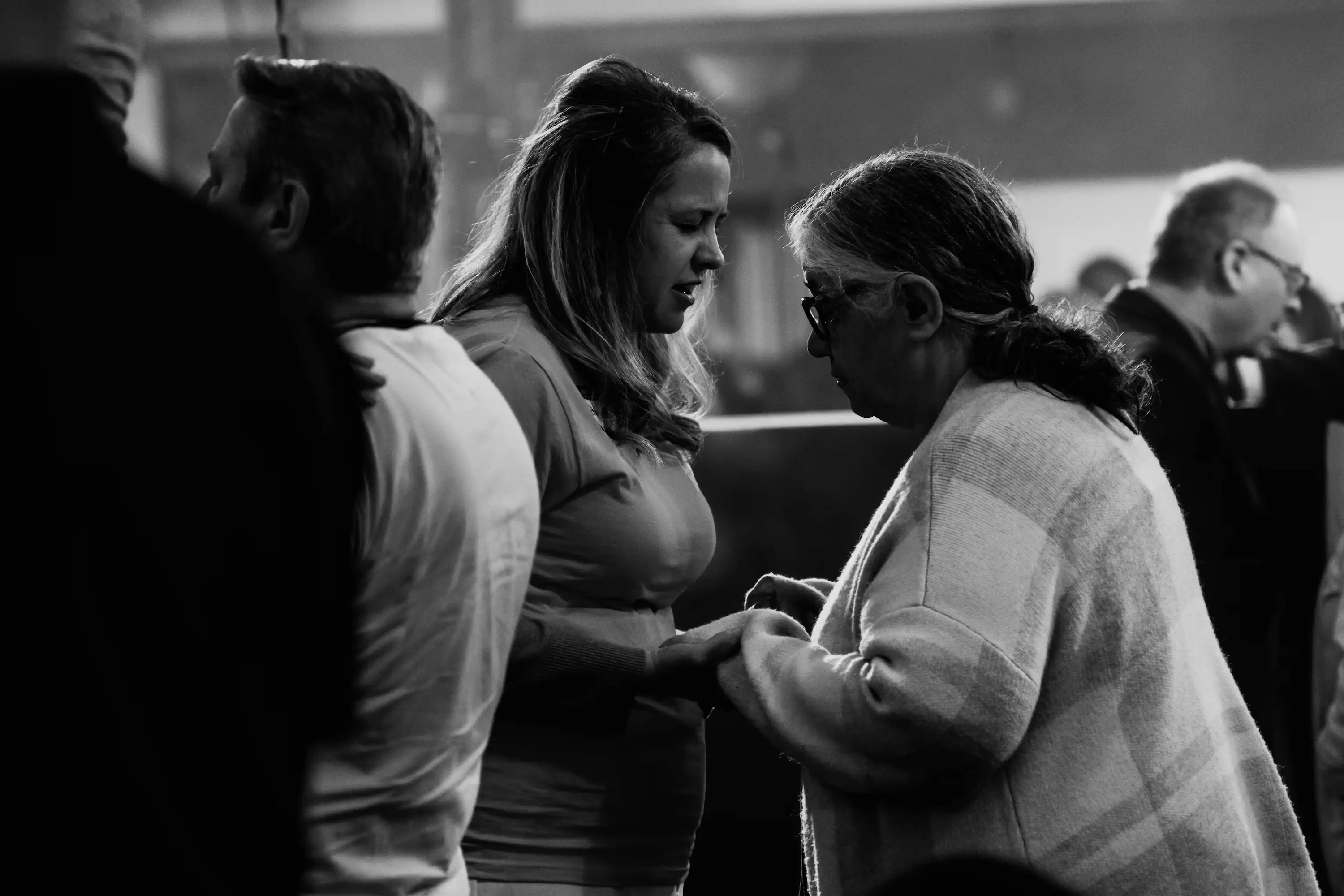 Two women praying together at AWAKE America Boston rally