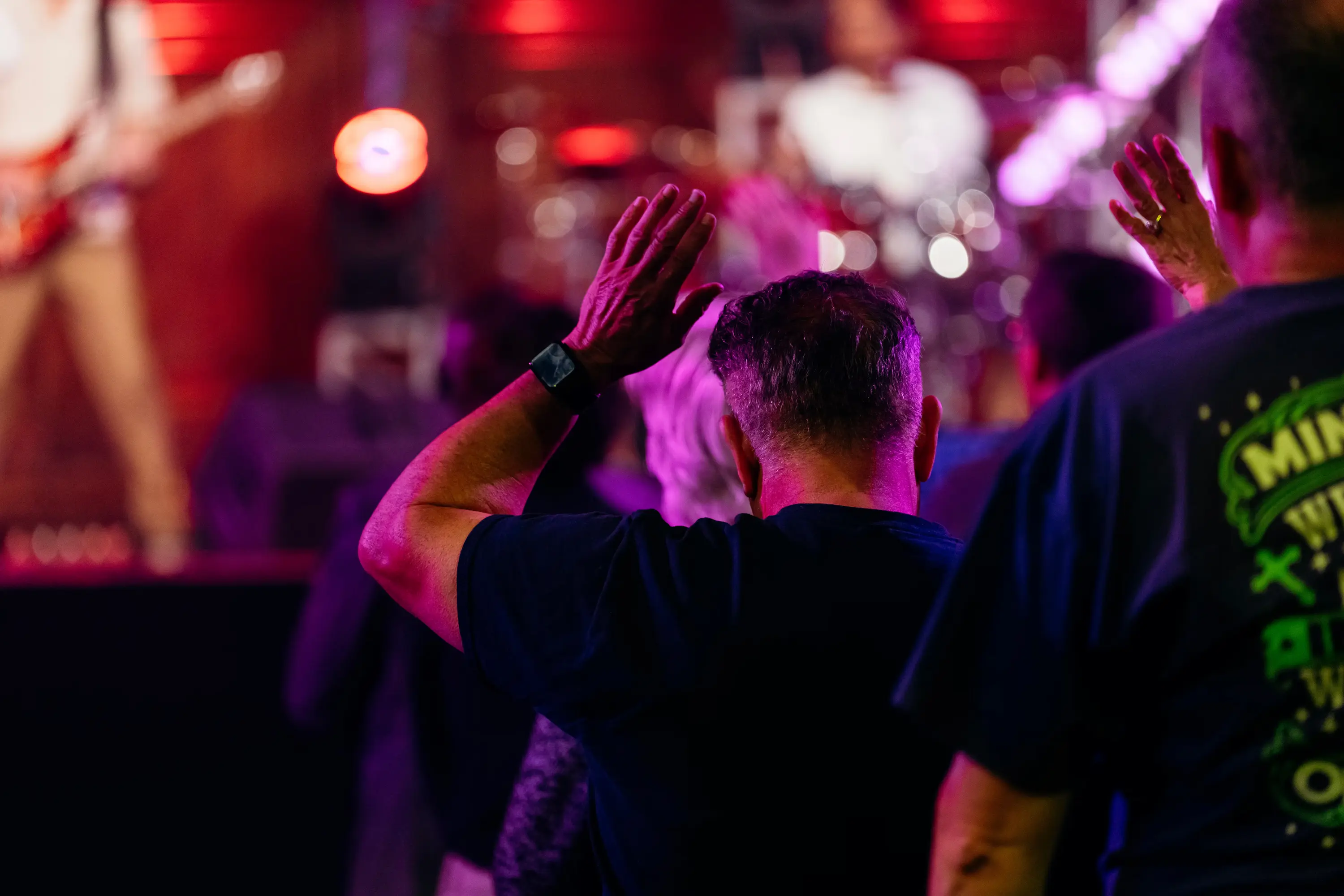 Attendee with hands raised in worship at AWAKE America Boston rally