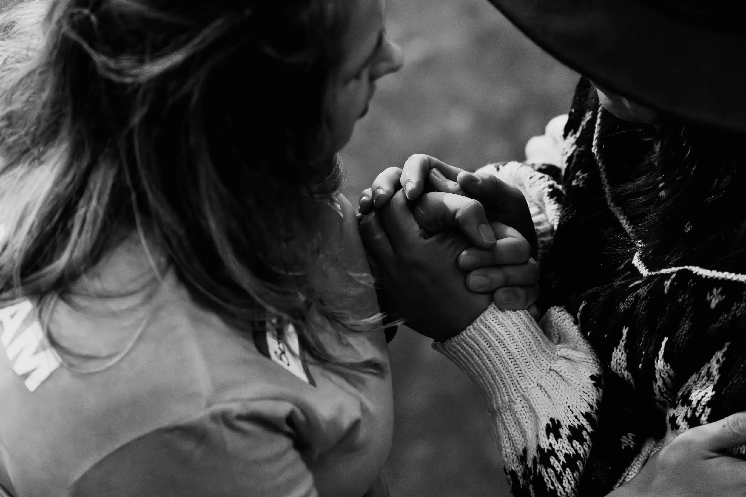 Two people holding hands in prayer at AWAKE America Boston rally