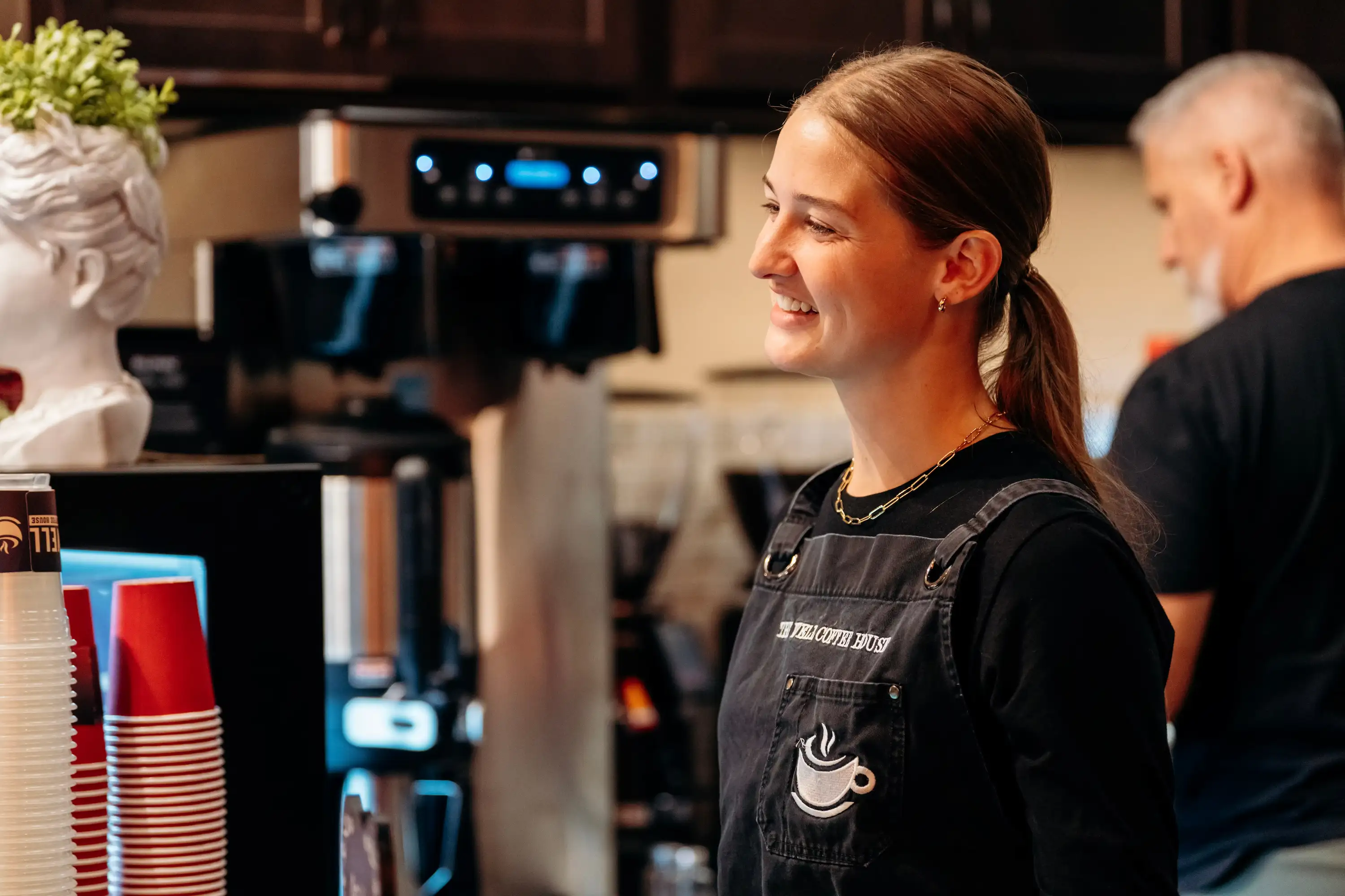 Barista smiling at The Well Coffee House station at AWAKE America Boston rally